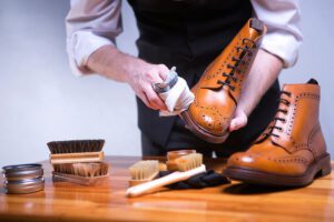 A man carefully cleaning leather boots.